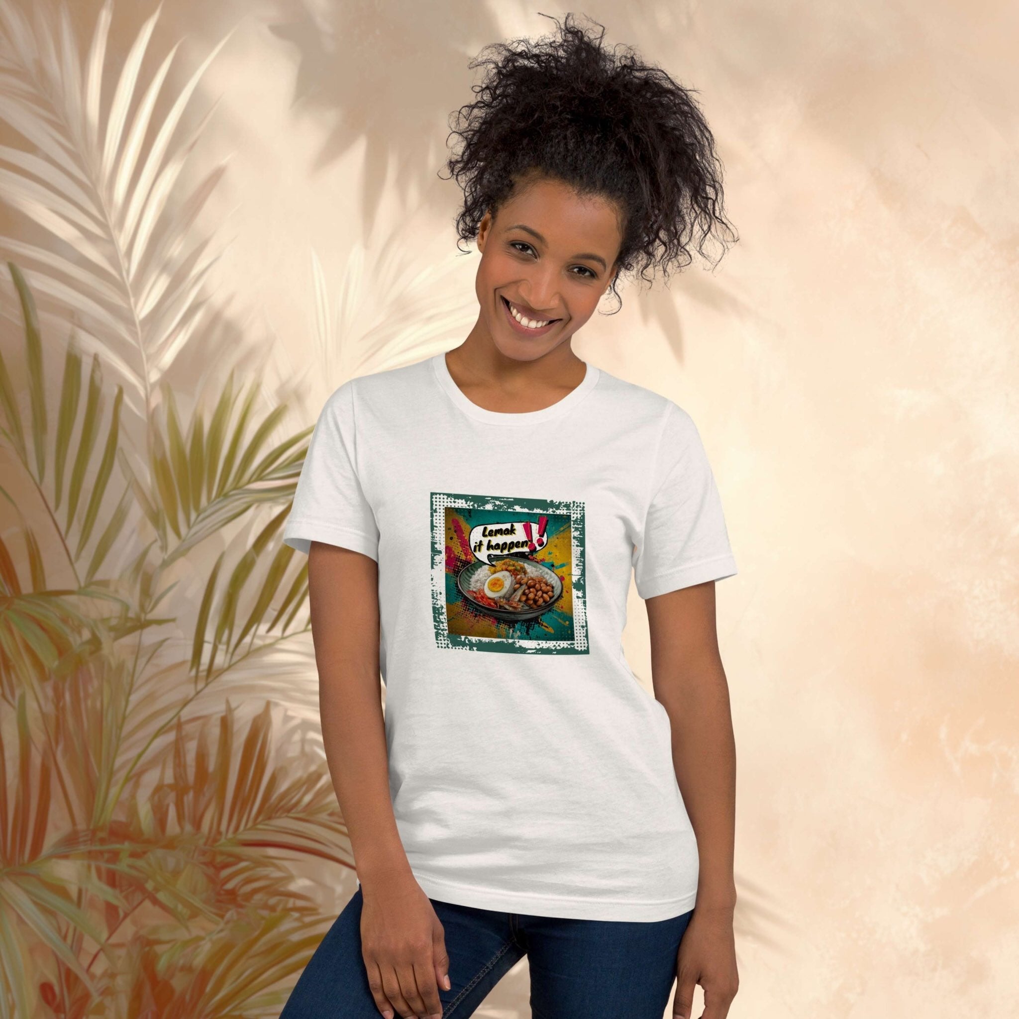 Woman wearing a white t-shirt with a colorful graphic design of Lemak It Happen Nasi Lemak pop art front print against a beige background with leaf patterns.