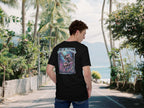 Chill Nomads Midnight Reef Turtle Backprint T-Shirt on a mann stand in the street with the ocean in the background