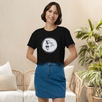 Woman wearing a black crop top with a white graphic coffee design, standing in a living room.