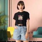 Person wearing a black crop top with colorful graphic design  of japanese ramen and denim shorts in a modern interior setting.