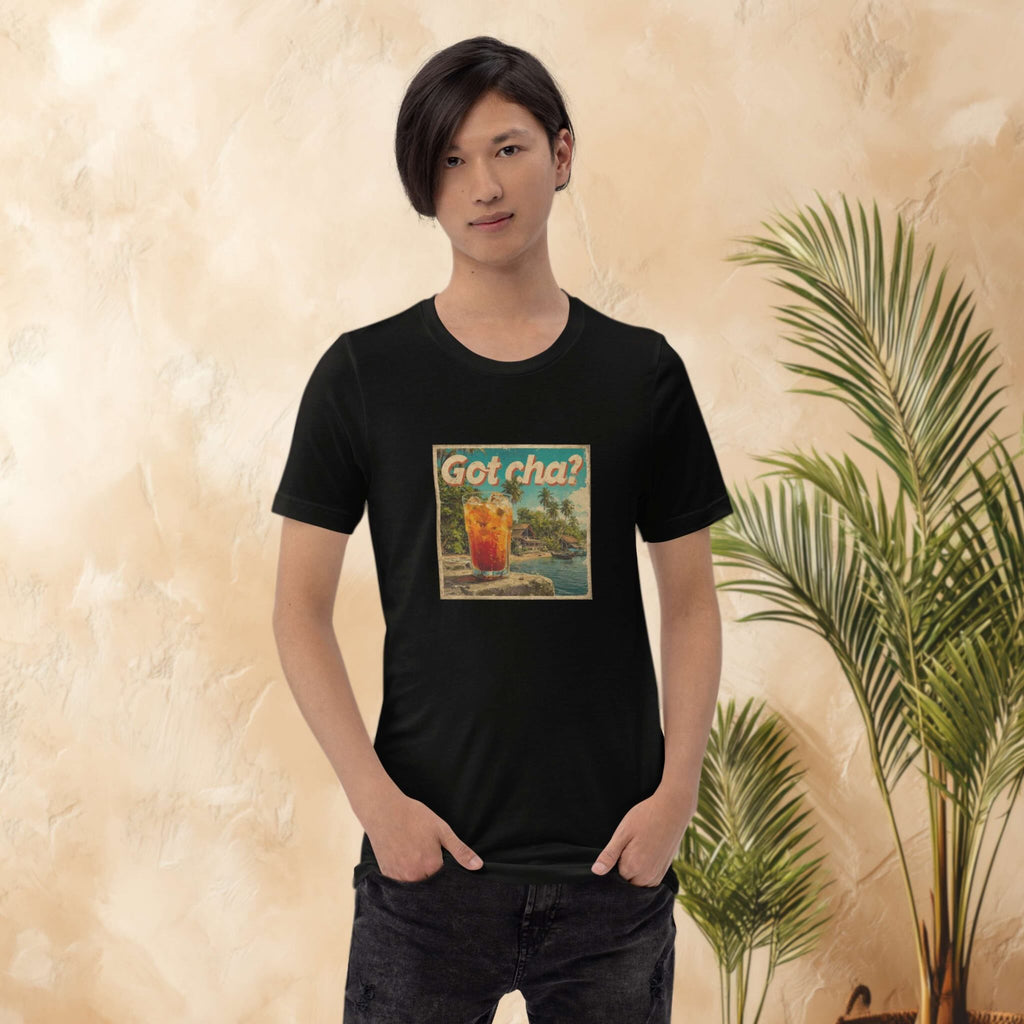 Person wearing a black t-shirt with a graphic design of thai milk tea in front of a beige wall with a plant.