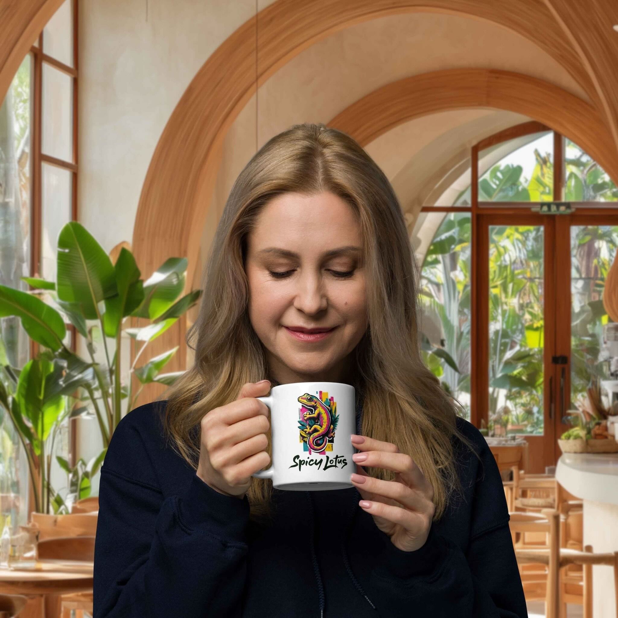 Woman holding a mug with a colorful gecko design in a cafe setting