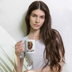 Woman holding a white mug with a gecko design against a plain background