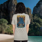 Person wearing a t-shirt with 'Island Dons' design in a scenic beach location.
