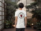 Person wearing a white t-shirt with a dragon enso graphic and text in an japanse indoor setting with plants and lanterns.