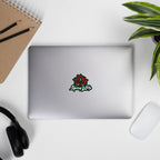 Laptop with Spicy Lotus logo sticker with lotus flower on a desk with a notebook, pencils, headphones, and a plant.
