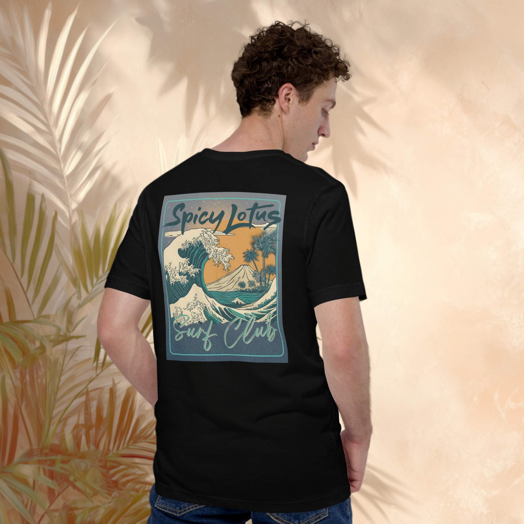 Person wearing a black t-shirt with a colorful Spicy Lotus Surf Club Bali volcano graphic on the back, standing against a beige wall with palm leaves.