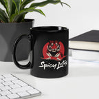 Black mug with a tiger design and 'Spicy Lotus' text on a desk with a plant and books in the background.