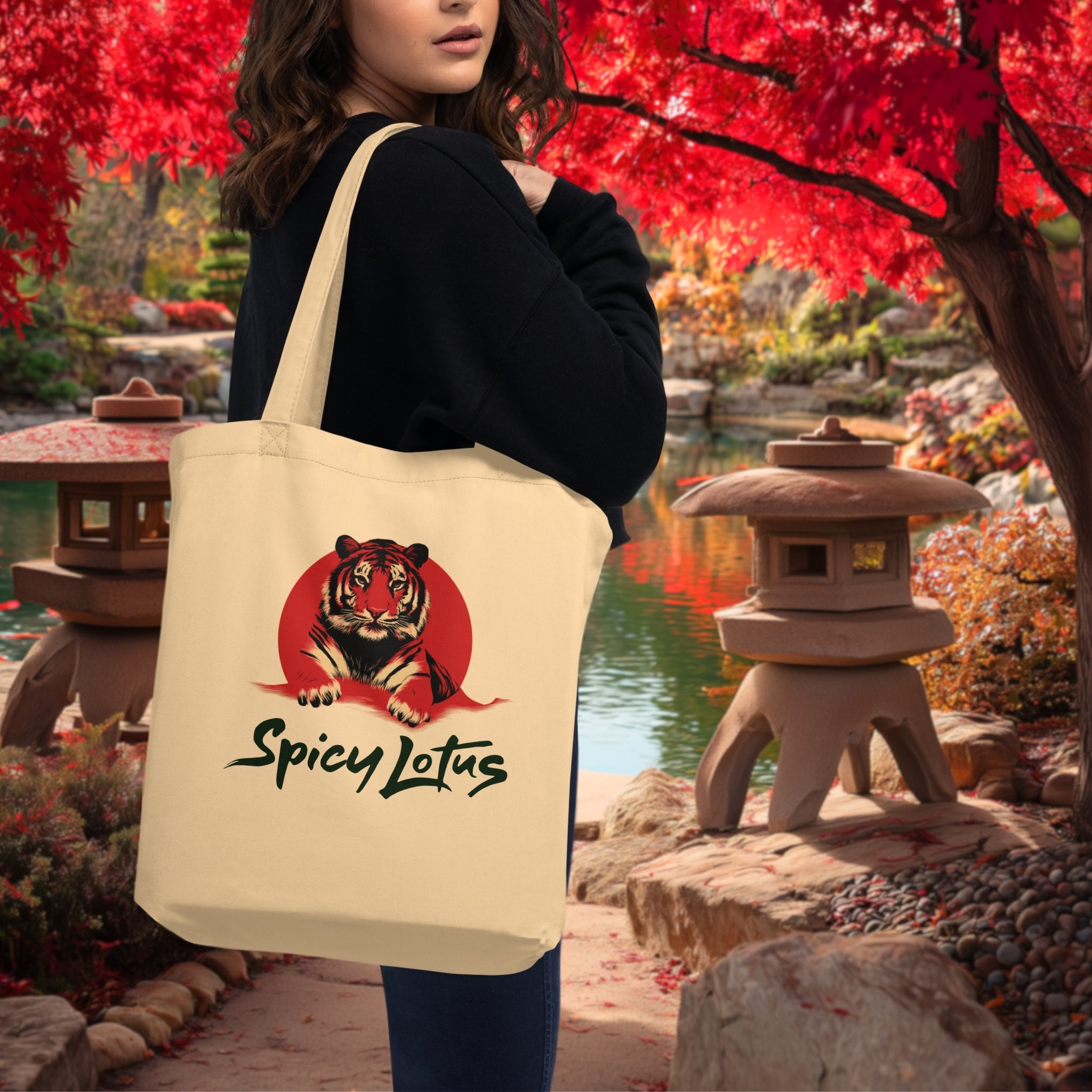 Woman holding a tote bag with a tiger design and 'Spicy Lotus' text in a garden setting.
