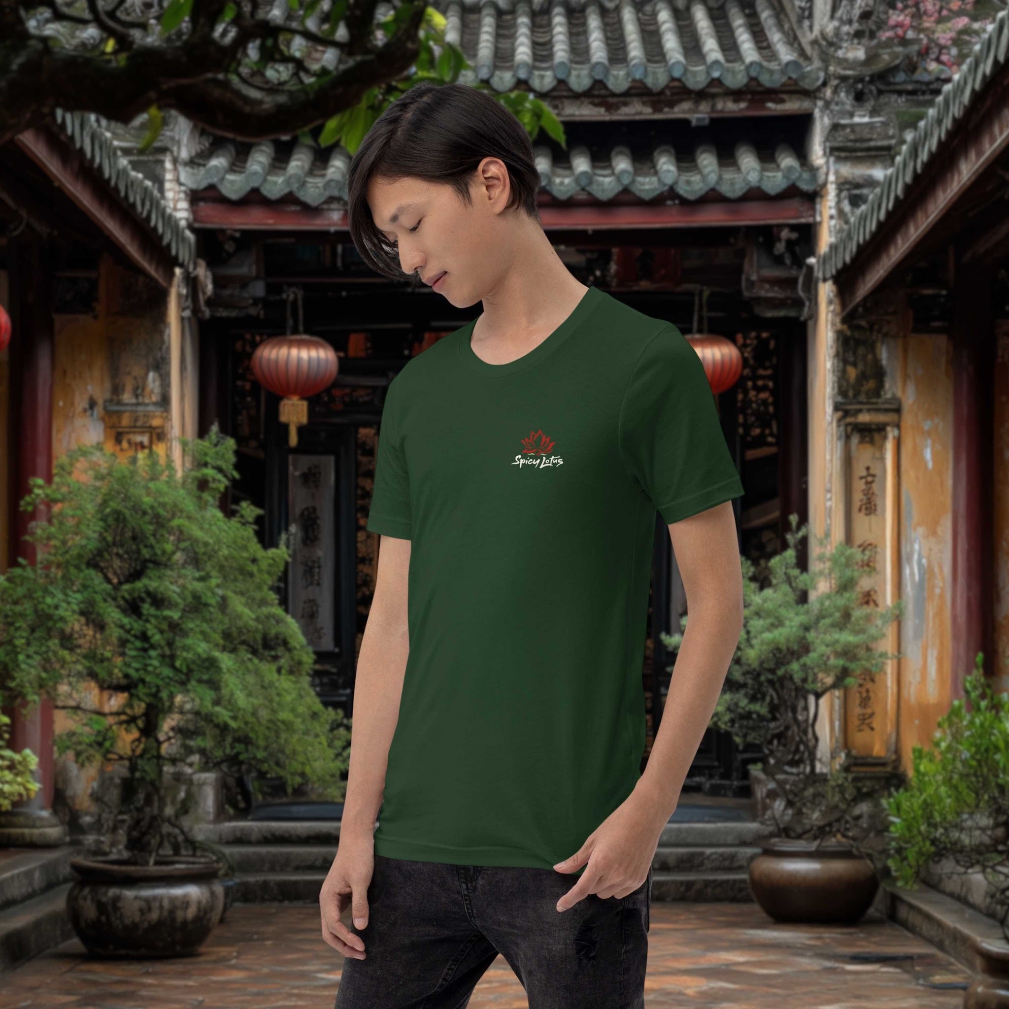 Person wearing a green t-shirt with a logo in a japanese outdoor setting with traditional architecture and plants.