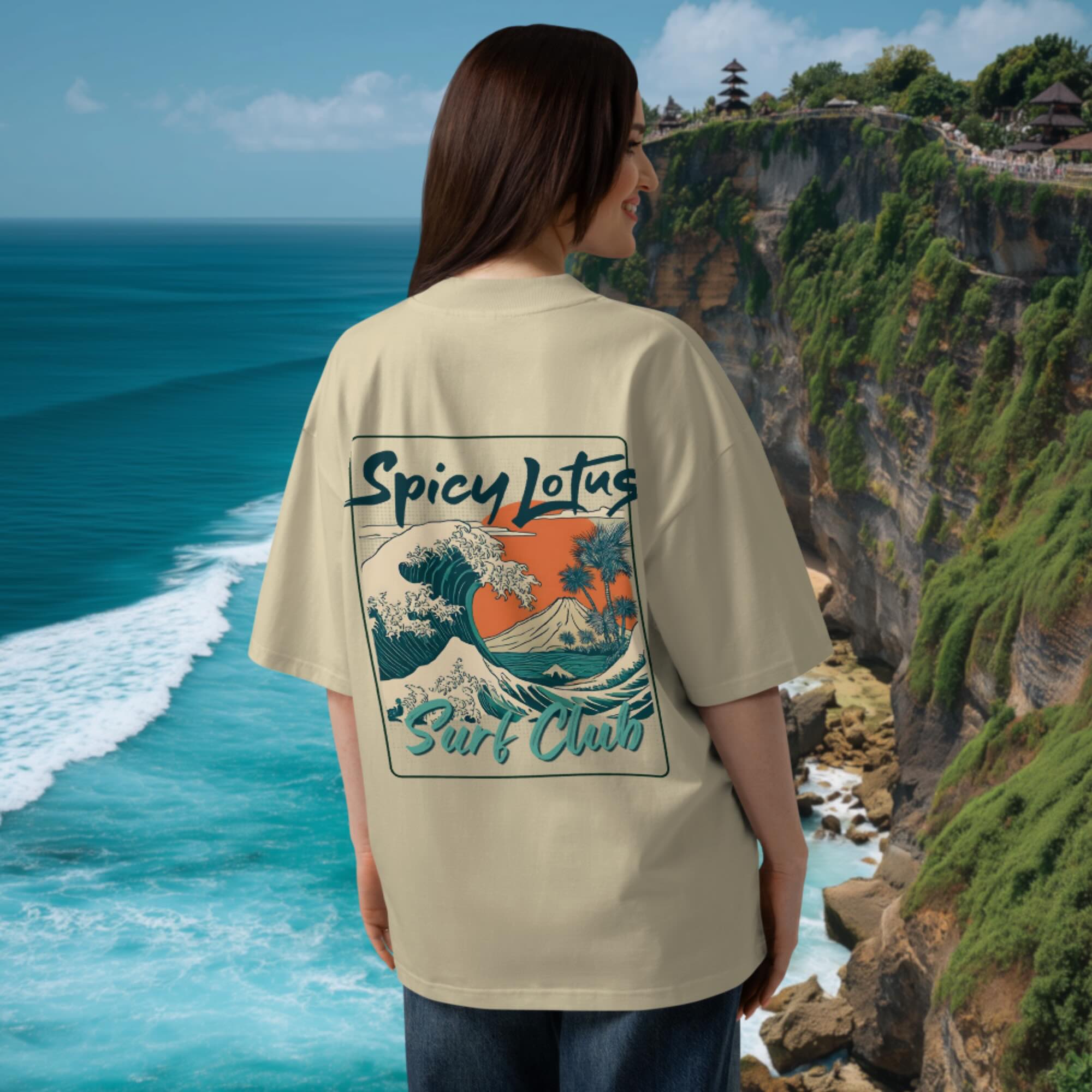Woman wearing a beige 100 % organic cotton t-shirt with 'Spicy Lotus Surf Club' design by the ocean in Uluwatu, Bali, Indonesia.