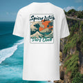 White t-shirt with 'Spicy Lotus Surf Club' design against a scenic ocean backdrop