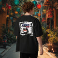 Person wearing a black t-shirt with a grafftiti graphic design of vietnamese soup pho in an outdoor setting with colorful lanterns, in Hoin An, Vietnam