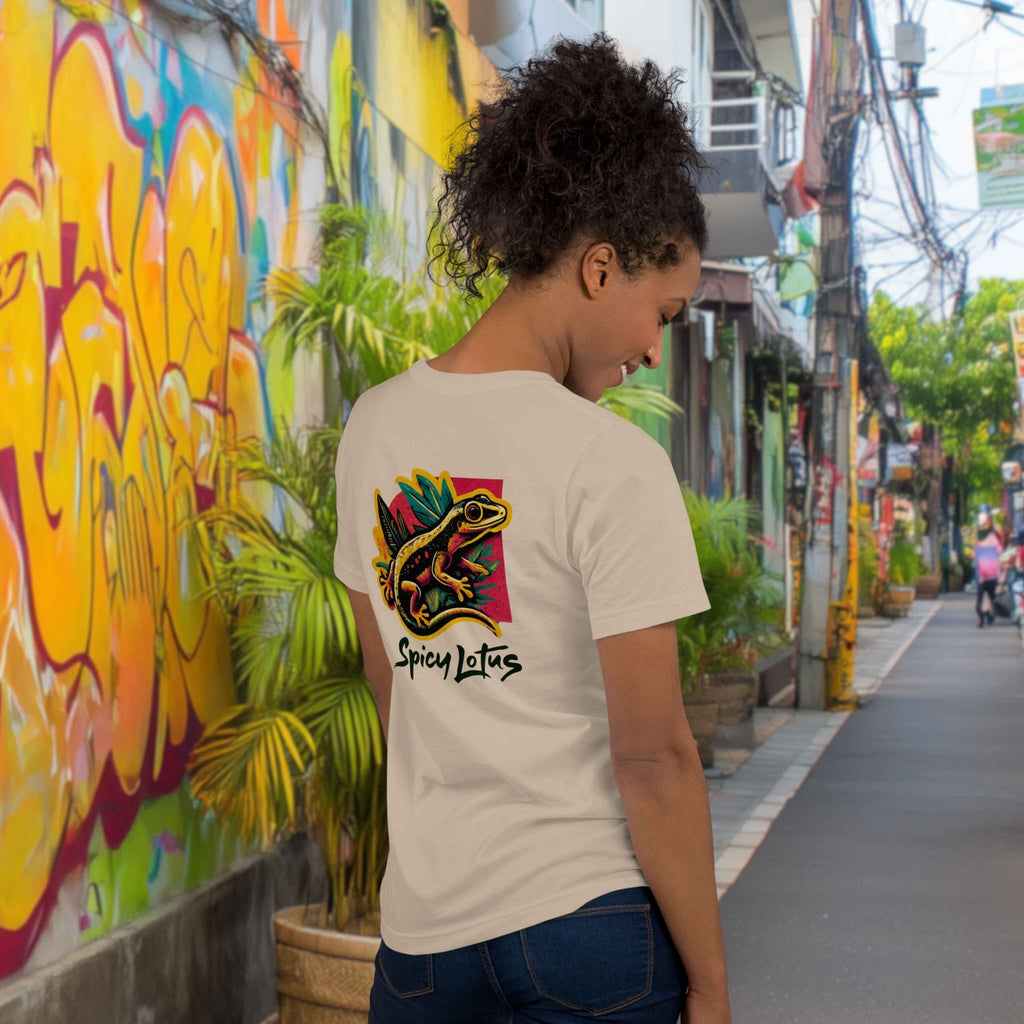 Woman standing in a colorful street in Asia wearing a Spicy Lotus Urban Gecko back print T-shirt in soft cream