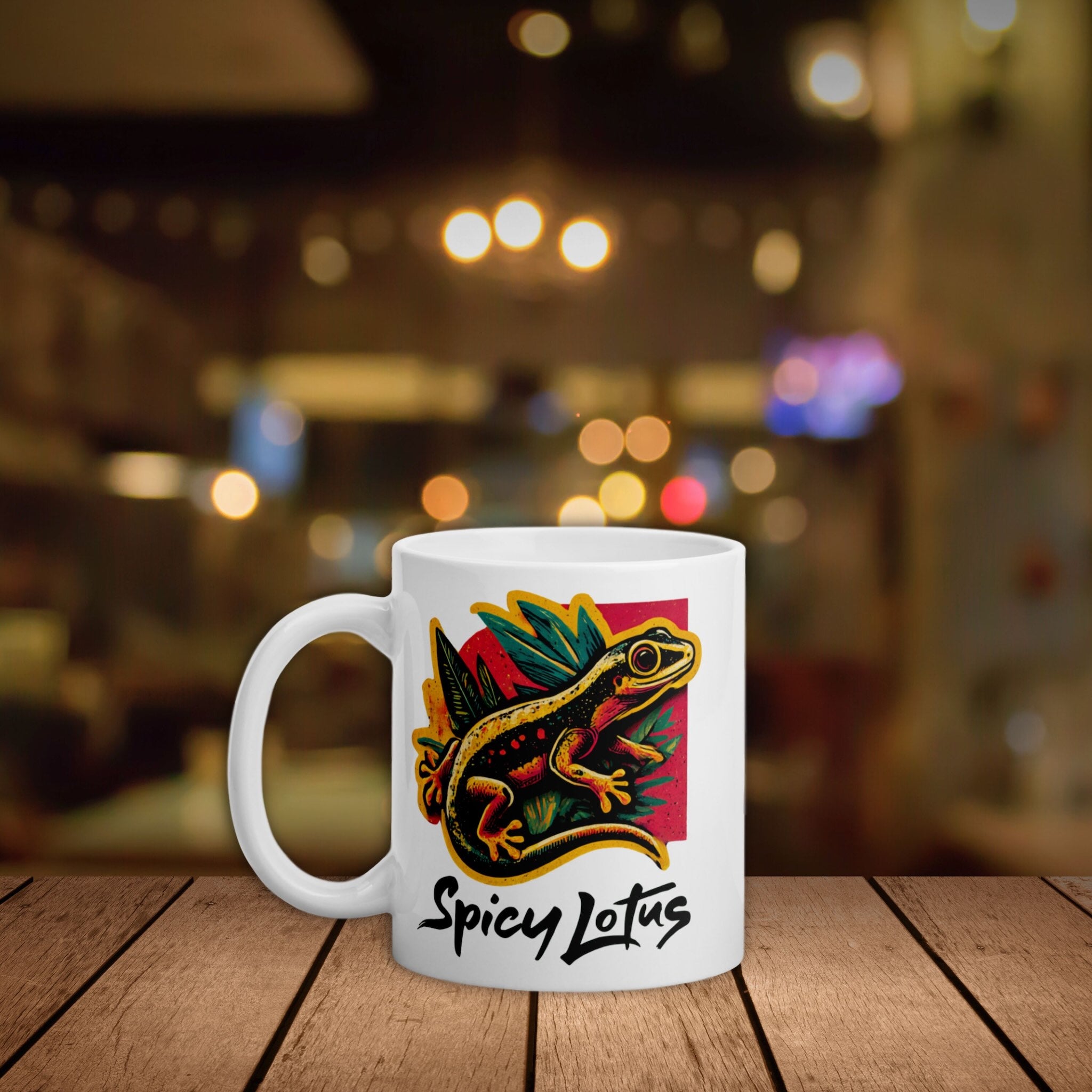 White mug with colorful gecko design and 'Spicy Lotus' text on a wooden surface with a blurred background.