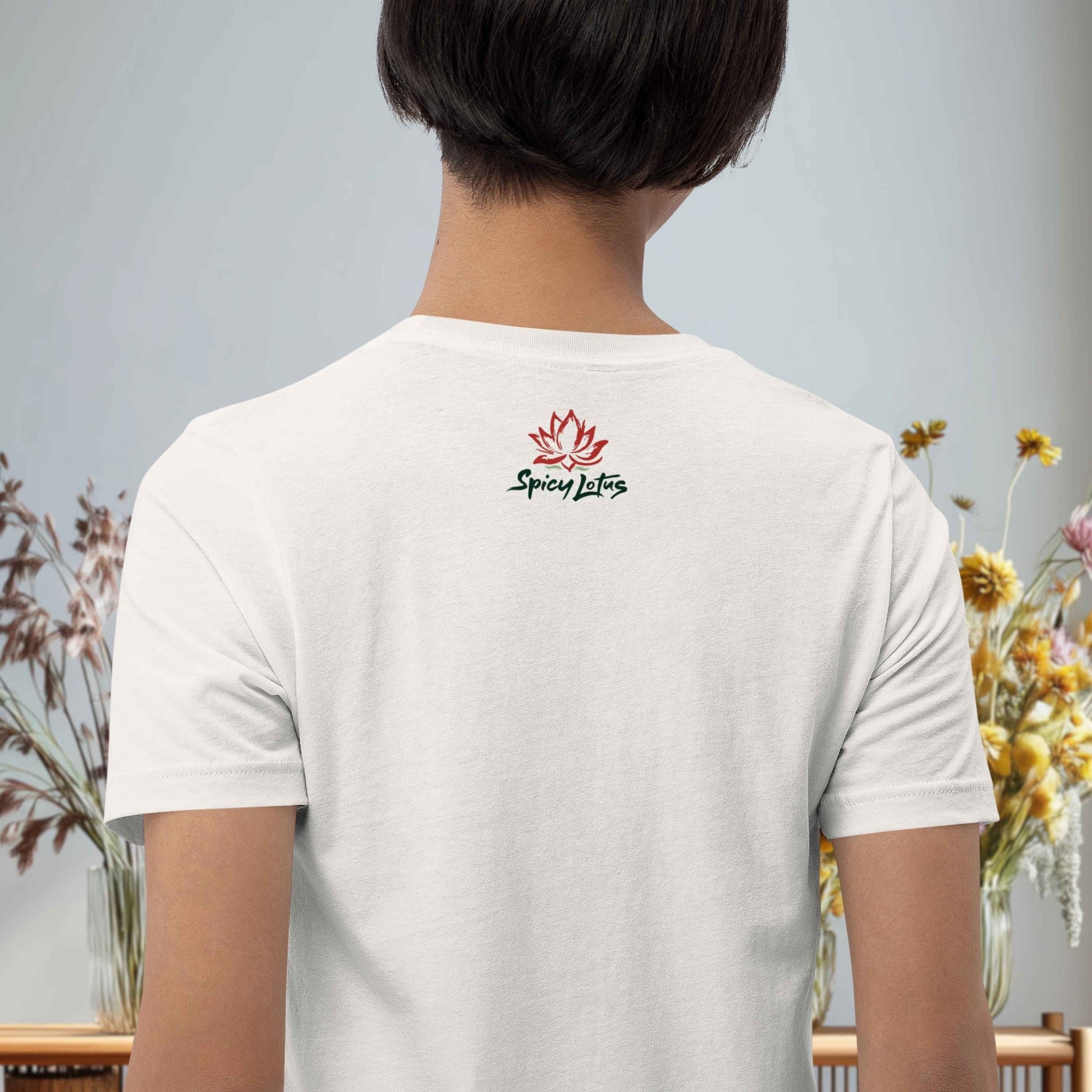 Person wearing a white t-shirt with 'Spicy Lotus' logo on the back, standing against a light gray background with floral decorations.