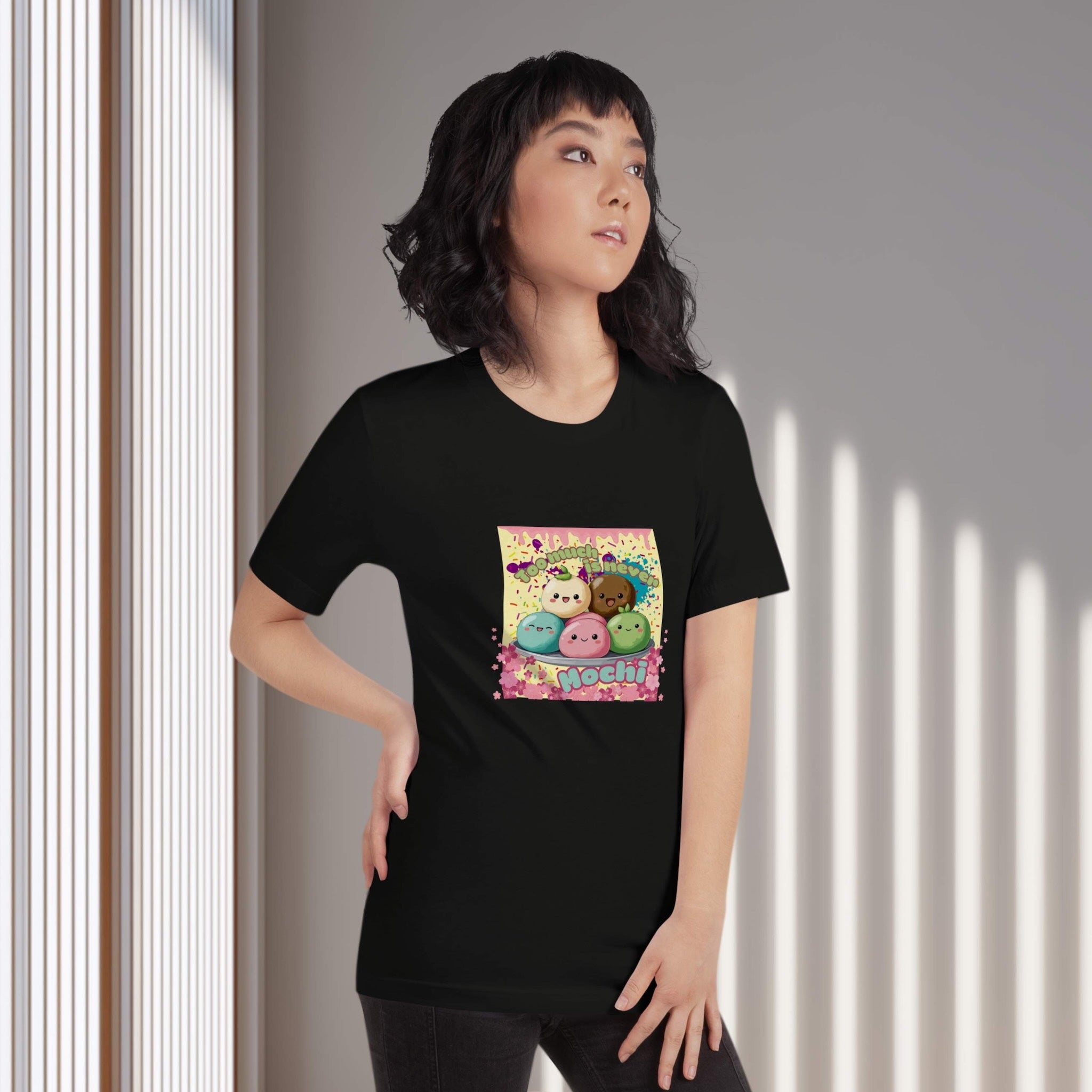 Person wearing a black t-shirt with colorful graphic design of cute mochis