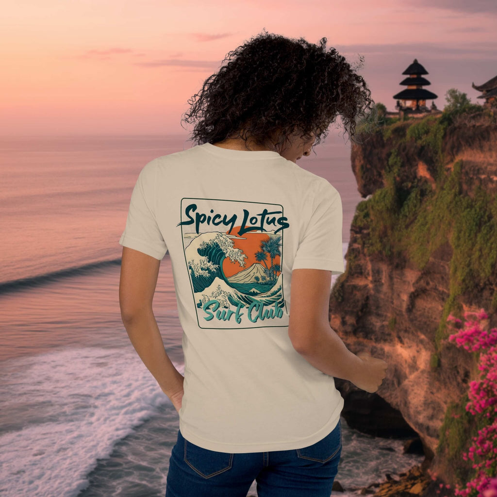 Spicy Lotus Surf Club Sunrise Wave back print T-shirt on a young woman in front a Uluwatu Cliffs showing balinese temple at sunset