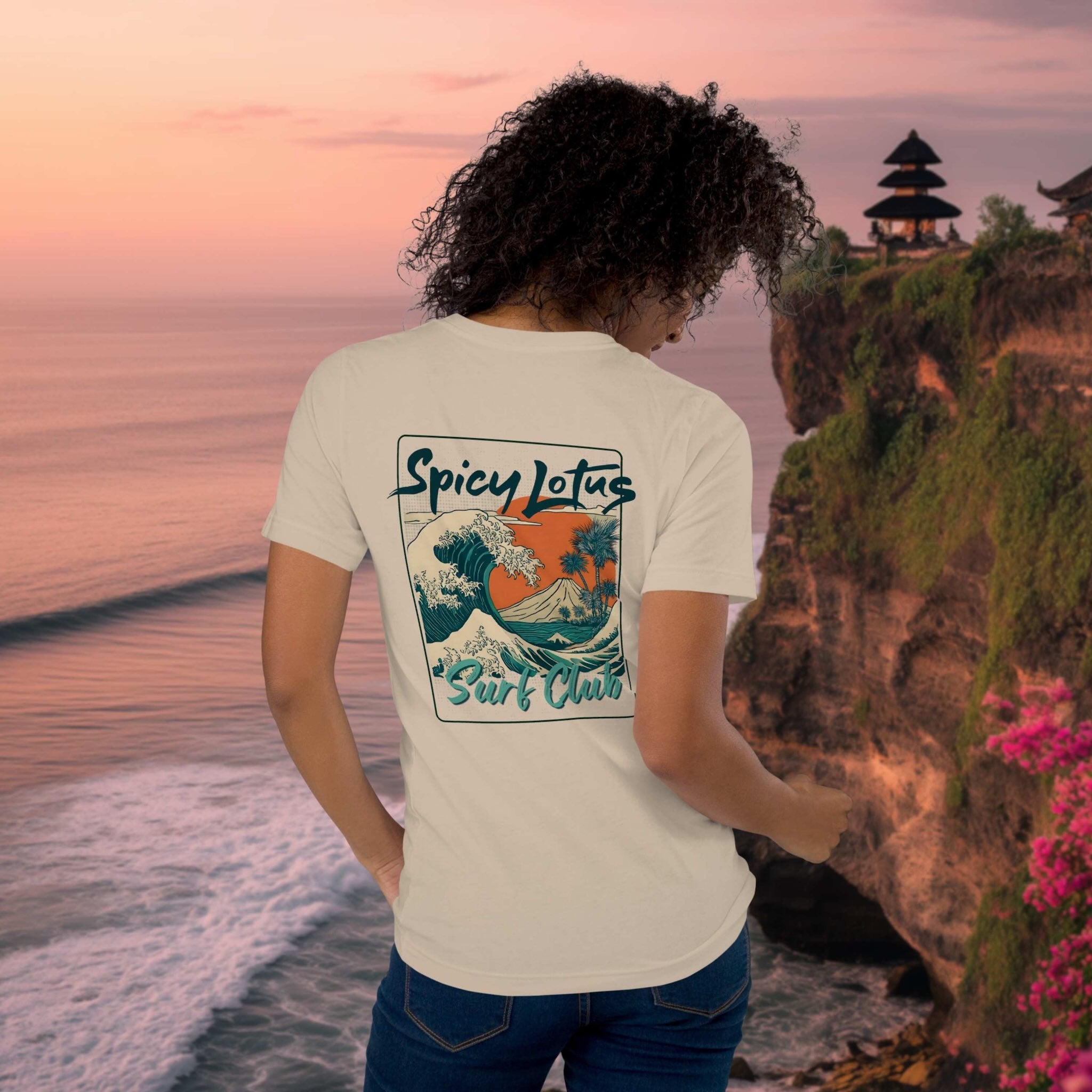 Spicy Lotus Surf Club Sunrise Wave back print T-shirt on a young woman in front a Uluwatu Cliffs showing balinese temple at sunset