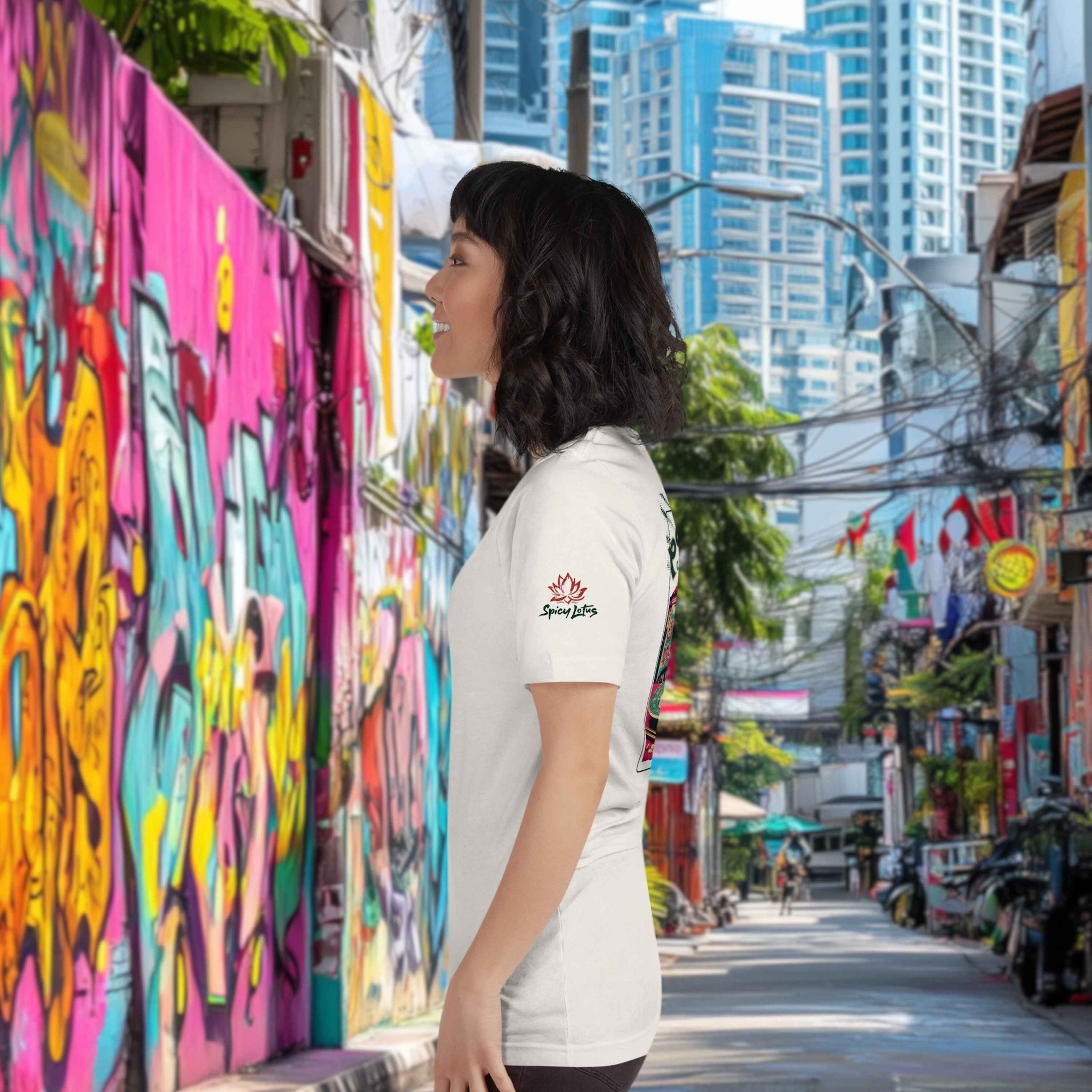 Woman standing in a colorful alleyway with graffiti and modern buildings in the background, wearing a Spicy Lotus tee with left sleeve logo