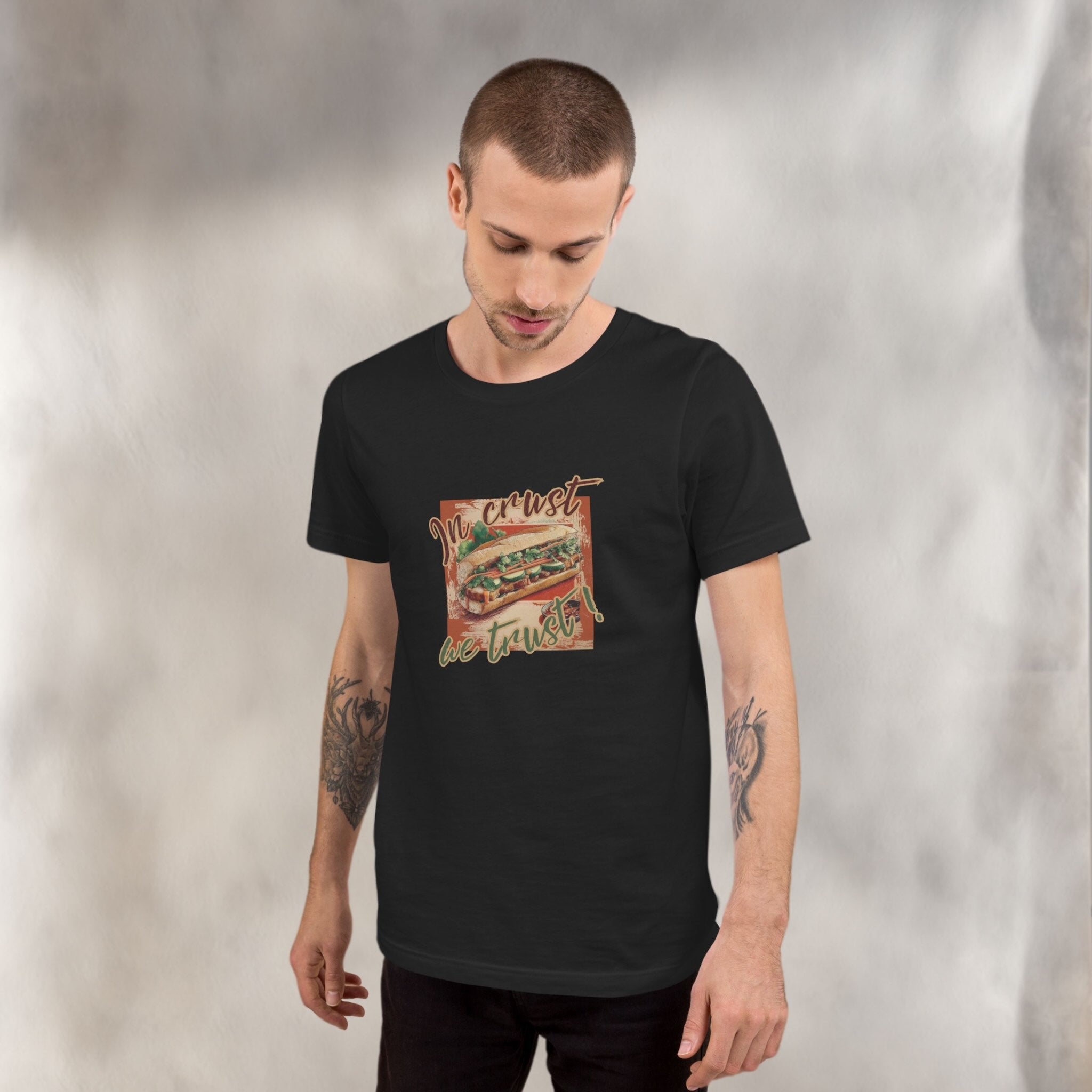Man wearing a black t-shirt with a graphic design on a plain background