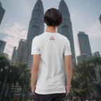 Person wearing a white t-shirt with a logo in front of the Petronas Twin Towers.