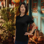 Woman wearing a black t-shirt with a logo in a decorative indoor setting