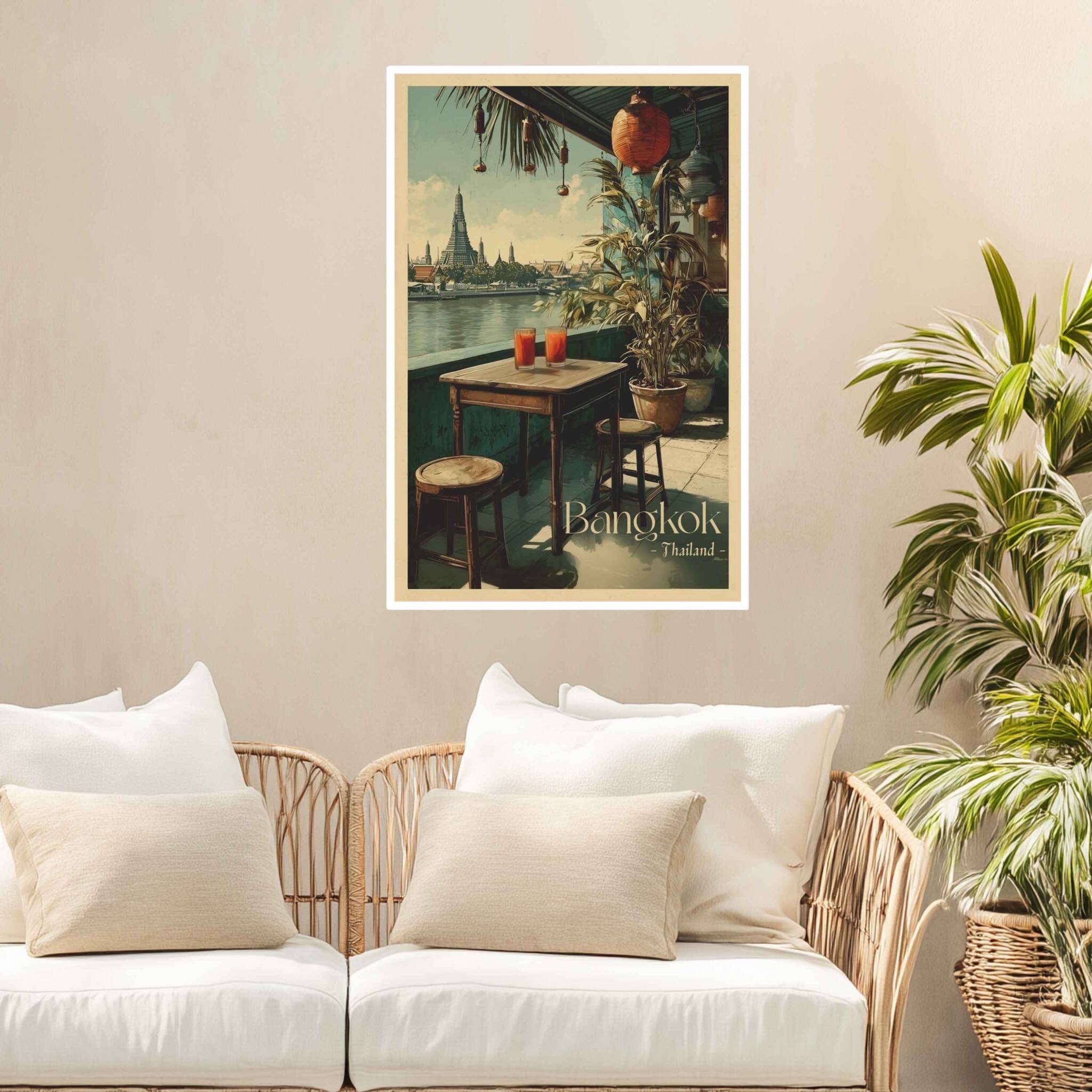 Poster of Bangkok on a wall above a sofa with decorative pillows and plants.