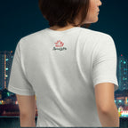 Person wearing a white t-shirt with a logo on the back against a cityscape background