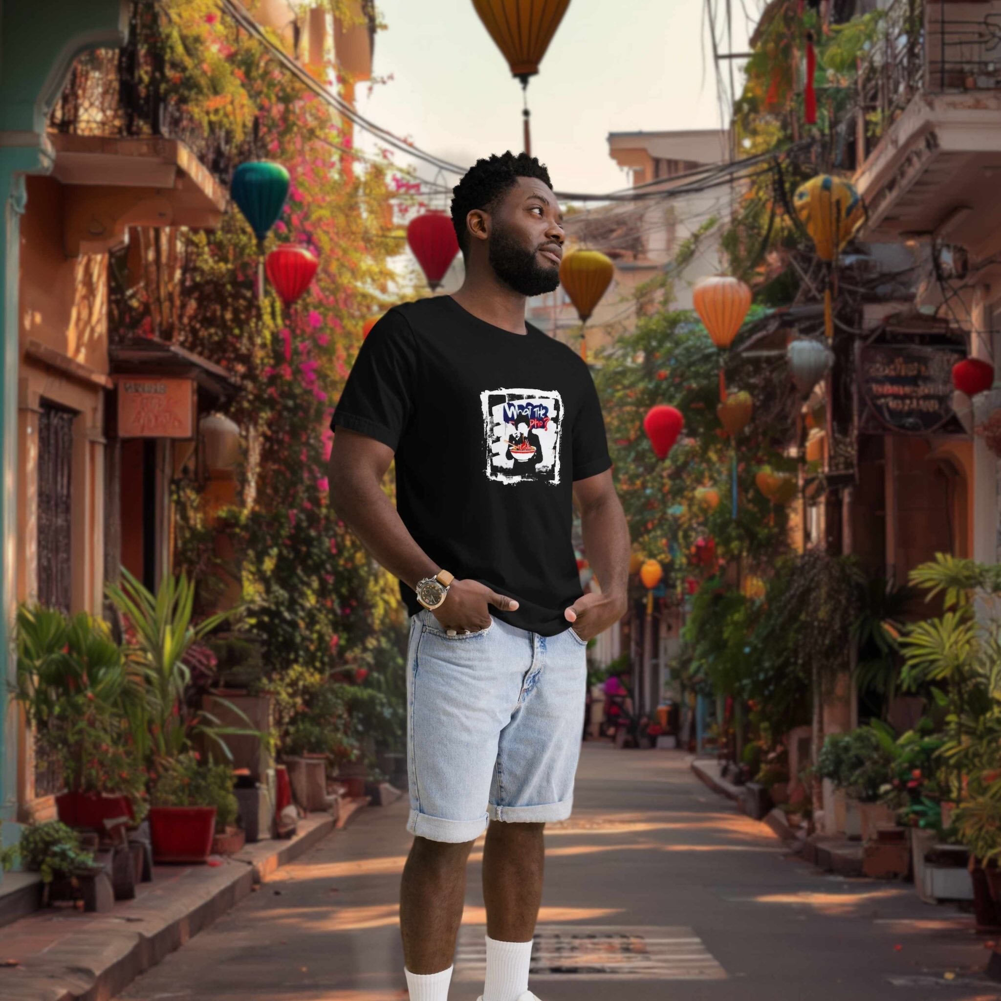 Man wearing a black t-shirt with a graphic design in a colorful street setting