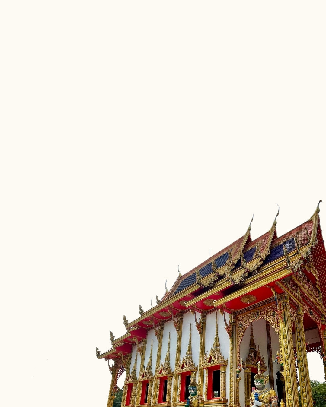 Thai temple with gold and red details on roof on a soft white background