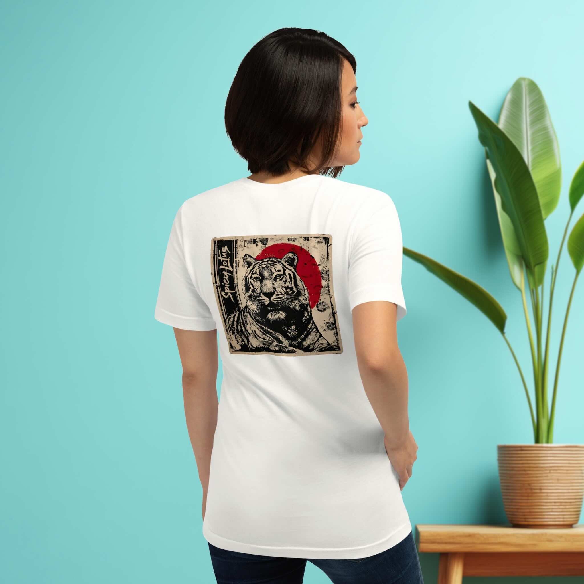 Woman wearing a Spicy Lotus Zen Tiger back print T-shirt in white, standing in front of a turquoise wall with a plant